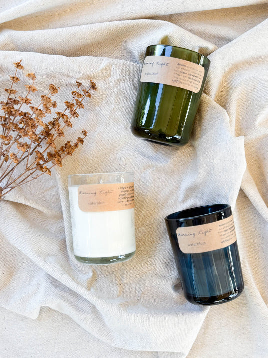Three candles of different sizes on a beige fabric background